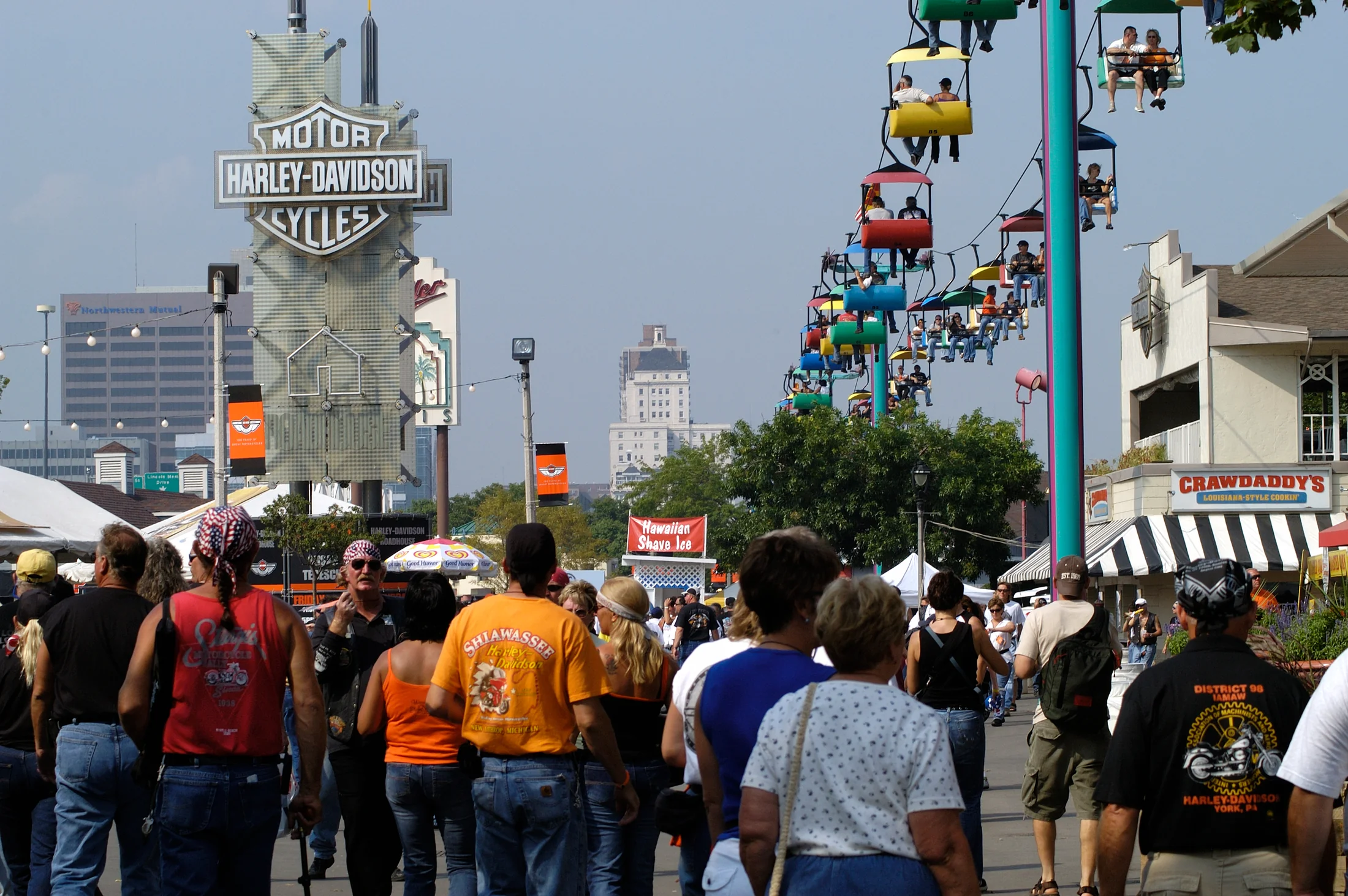 Crowd at a Harley-Davidson anniversary festival — riders, dealers, and community celebrating recovery
